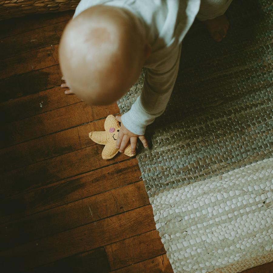 baby playing with handmade crochet yellow star baby rattle