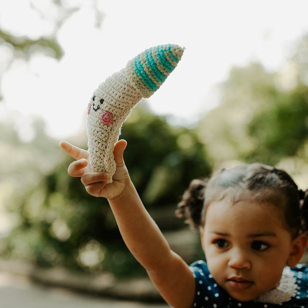 Girl holding smiling crescent moon handmade plush toy rattle