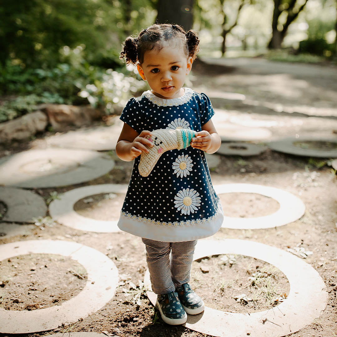 Girl with handmade crochet fair trade moon baby rattle