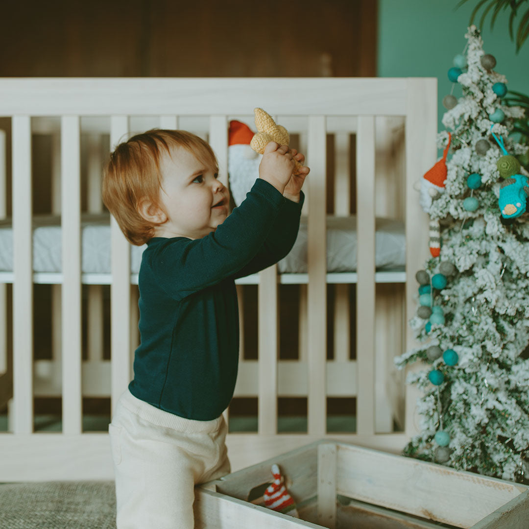 Toddler holding up plush star baby rattle
